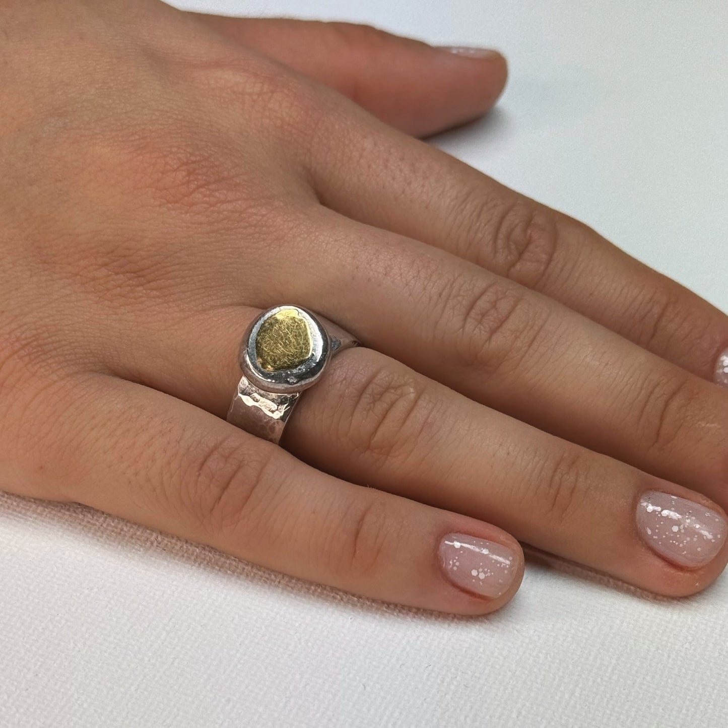 Gehamerde brede zilveren ring met gouden toplaag