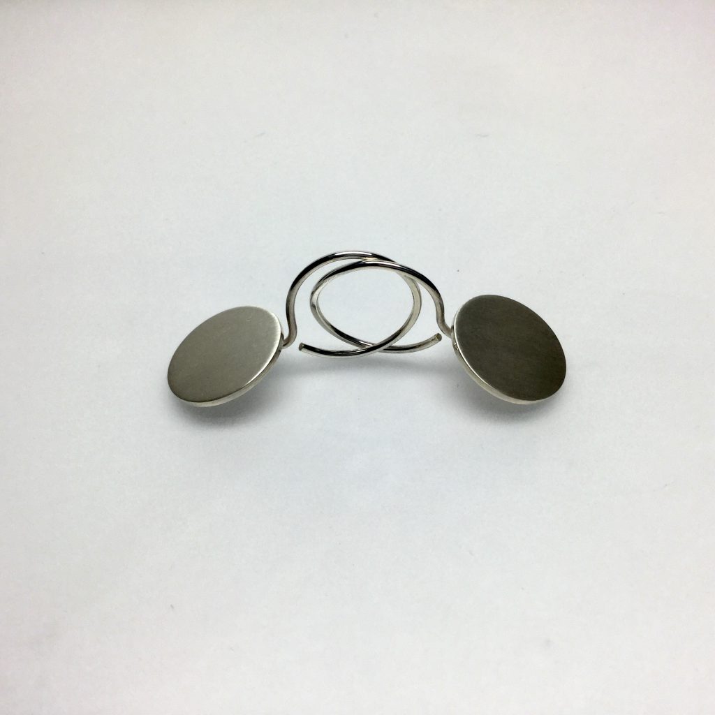 Foto van zilveren oorbellen met een rond schijfje.