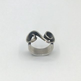 Foto van zilveren ring met sierlijke golf.
